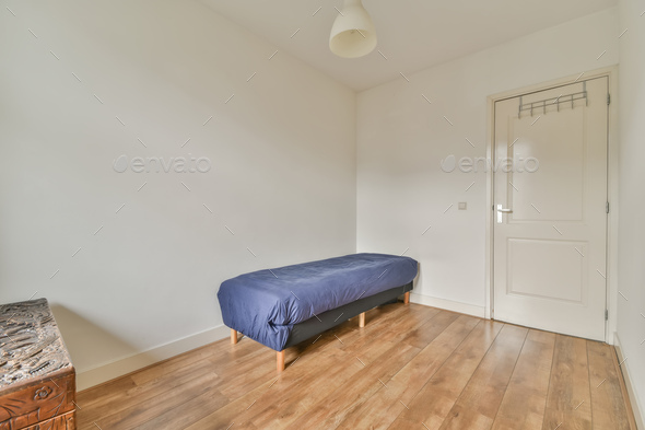 A small room with a single couch in blue