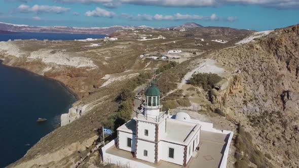 4k aerial drone flying over beautiful lighthouse Santorini Greece alt
