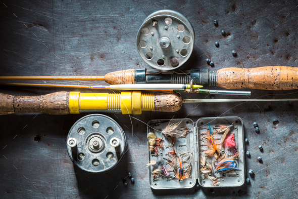 Vintage fishing tackle with flies and rods. Fishing preparation Stock Photo  by Shaiith