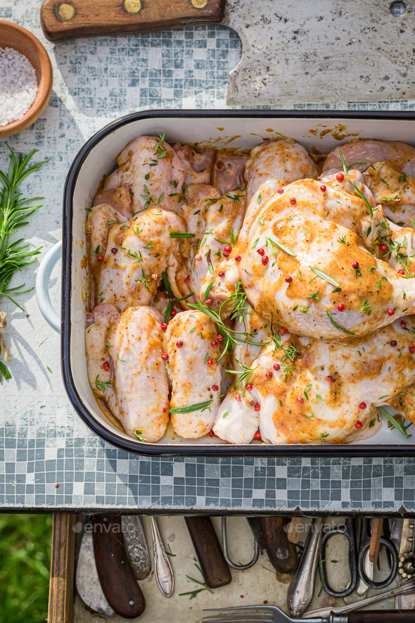 Seasoning chicken legs with herbs for grilling Stock Photo by Shaiith