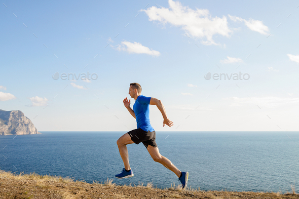 male runner running trail on sea coast - Stock Photo - Images