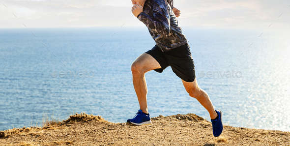 male athlete start running on sea background - Stock Photo - Images