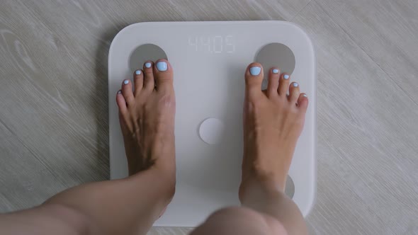 Female Bare Feet Stepping on Digital Floor Scales  Woman Weighing Herself