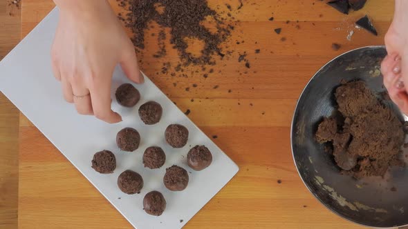 Woman Rolls Sweet Cocoa Dough With Her Hands and Makes Small Balls