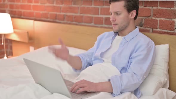 Young Man Get Upset on Laptop in Bed alt