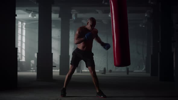 Man Hitting Punch Bag During Intense Workout alt