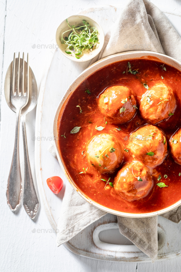 Top view of hot meatballs with fresh herbs and tomatoes Stock Photo by