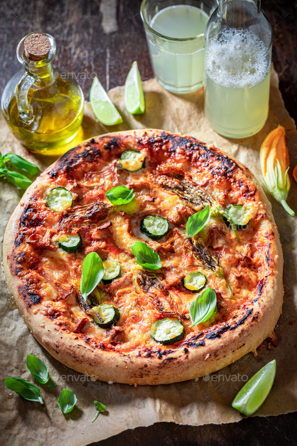 Homemade pizza with zucchini flower, chanterelles and mozzarella
