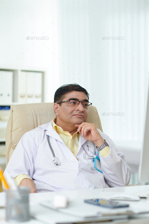 Doctor Leaning Back in Armchair Stock Photo by DragonImages PhotoDune