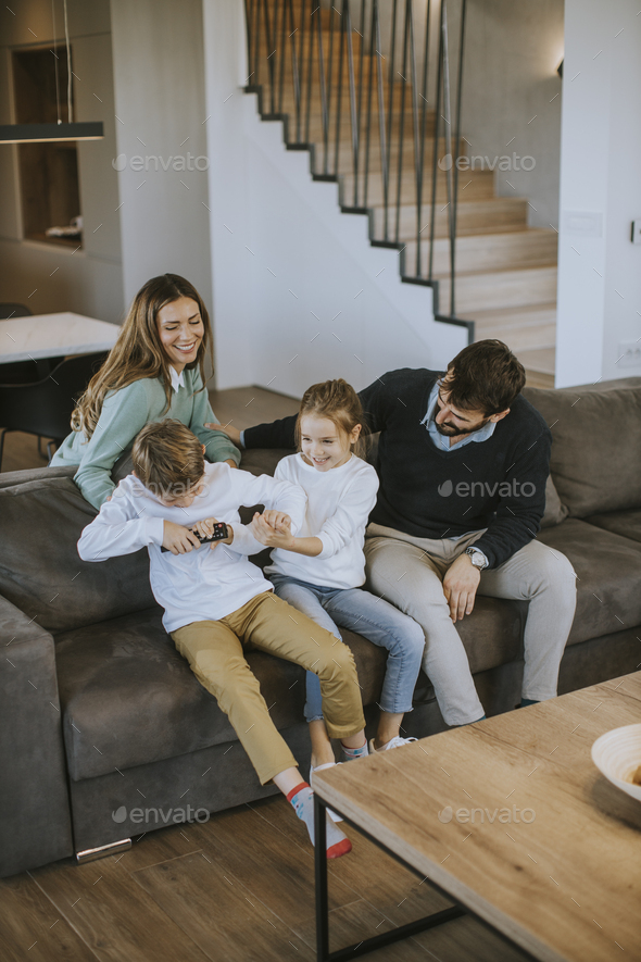 Siblings fighting over TV remote control at home