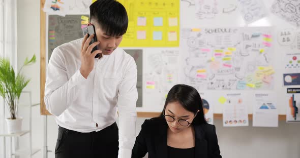 Man team leader coach mentor with employee while talking on phone alt