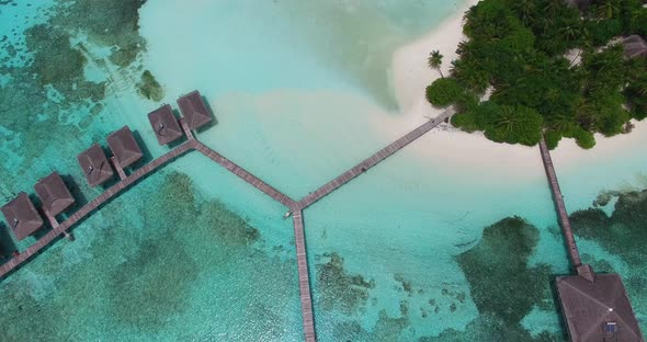Aerial view of paradise island in Maldives with white sand, turquoise water and green palm trees