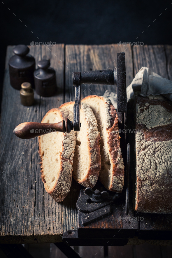 Homemade tasty loaf of bread on old slicer