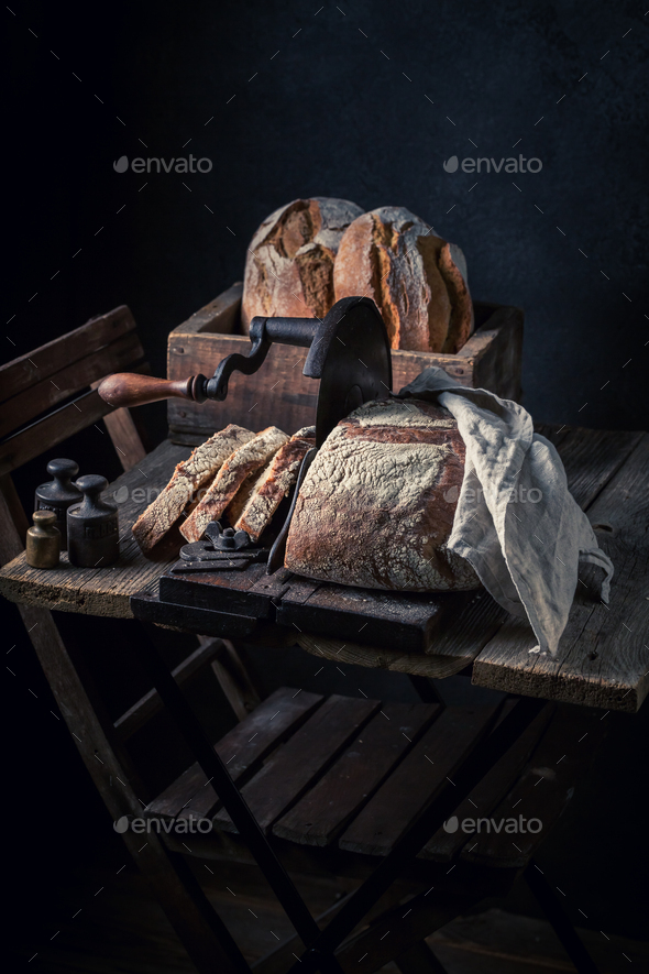 Homemade and tasty loaf of bread on old slicer