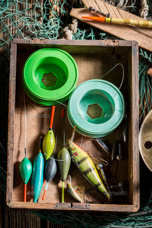 Closeup of vintage fishing tackle with fishing rod and lures Stock Photo by  Shaiith