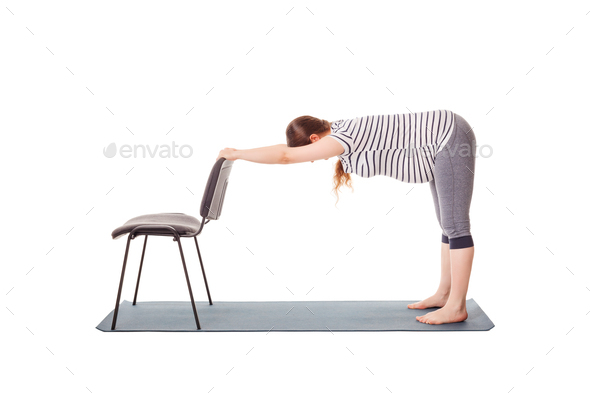 Pregnant woman doing yoga asana Uttanasana