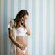 Pregnant woman wearing lingerie and posing in the room Stock Photo by  BGStock72