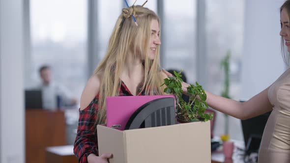 Portrait of Excited Young Hipster Woman Standing in Office Holding Box with Belongings As Passing alt