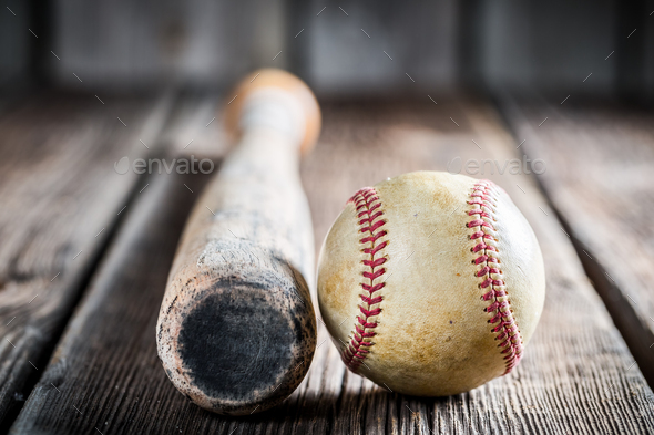 Baseball bat and ball on old wooden table