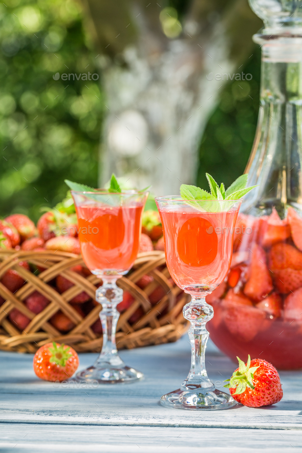 Homemade strawberry liqueur served in the garden Stock Photo by Shaiith