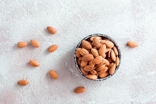 Fresh peeled almonds in a bowl on a light background. A source of vitamins and oils.