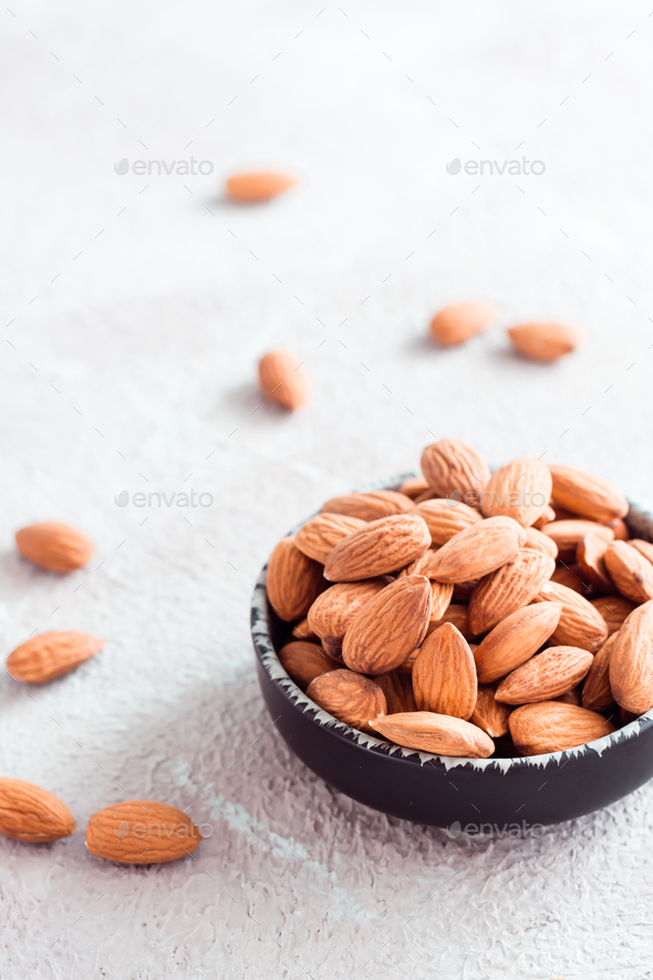Fresh peeled almonds in a bowl on a light background. A source of vitamins and oils.