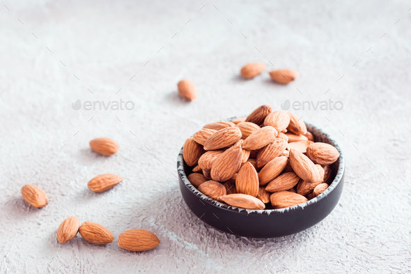 Fresh peeled almonds in a bowl on a light background. A source of vitamins and oils. Organic food