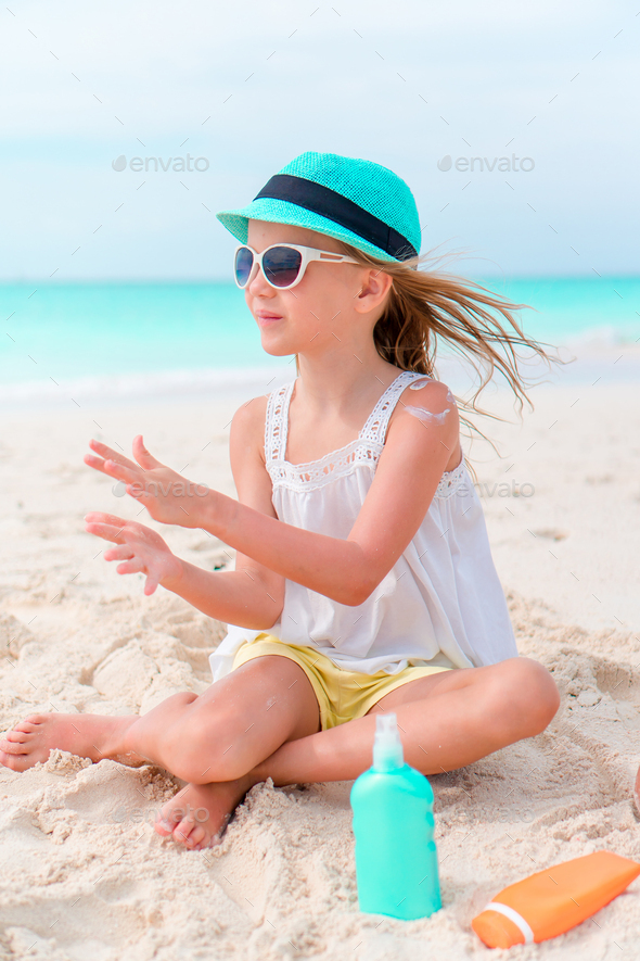 Little girl with bottle of sun cream - Stock Photo - Images