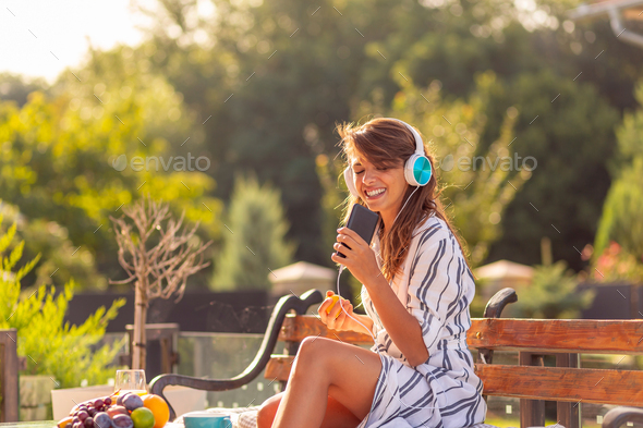 Woman wearing headset listening to the music and singing