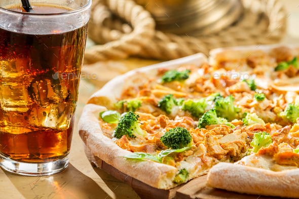 Fresh pizza with broccoli and chicken served with cold cola