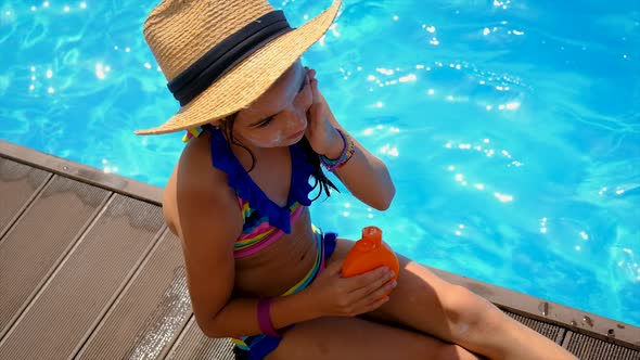 The Child is Applying Sunscreen alt