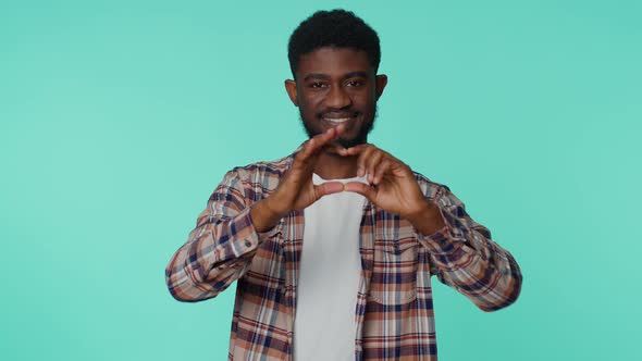 Smiling African American Man Makes Heart Gesture Demonstrates Love Good Sign Feelings and Sympathy alt