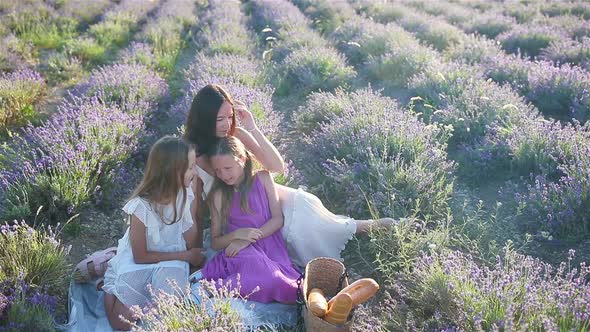 Family in Lavender Flowers Field at Sunset in White Dress and Hat