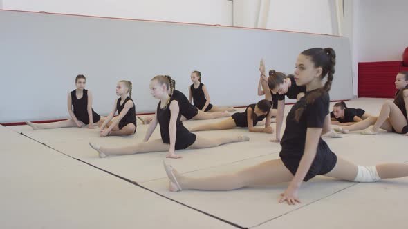Girls Stretching Legs before Gymnastics Practice alt