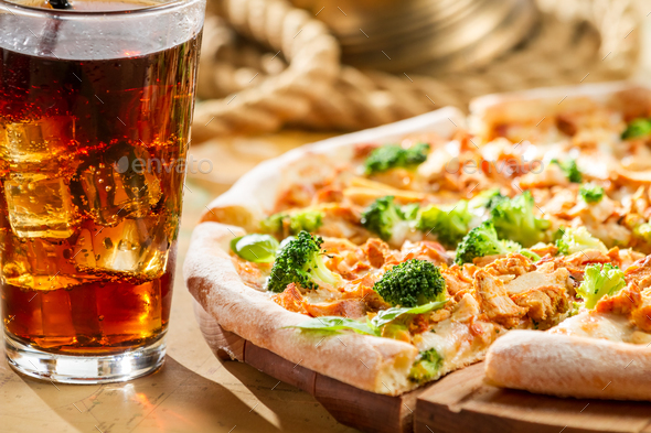 Fresh pizza with broccoli and chicken served with cold cola