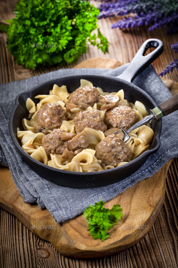 Pork meatballs with noodles in a cast iron skillet. Stock Photo by foto_pstryki