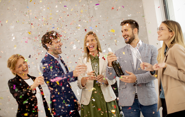 Group of business people celebrating and toasting with confetti falling ...