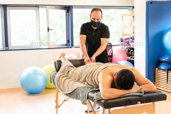 Therapeutic leg massage and sports recovery osteopathy. A sporty man receiving