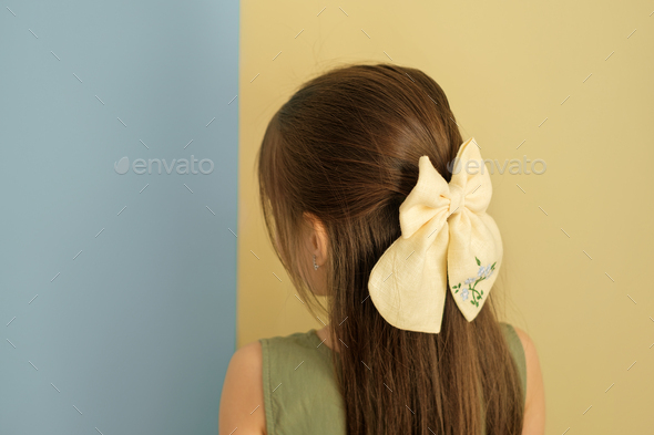 Bow is an accessory for the hair on the girl\'s head.