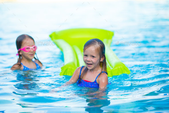 Adorable little girls playing in outdoor swimming pool Stock Photo by ...