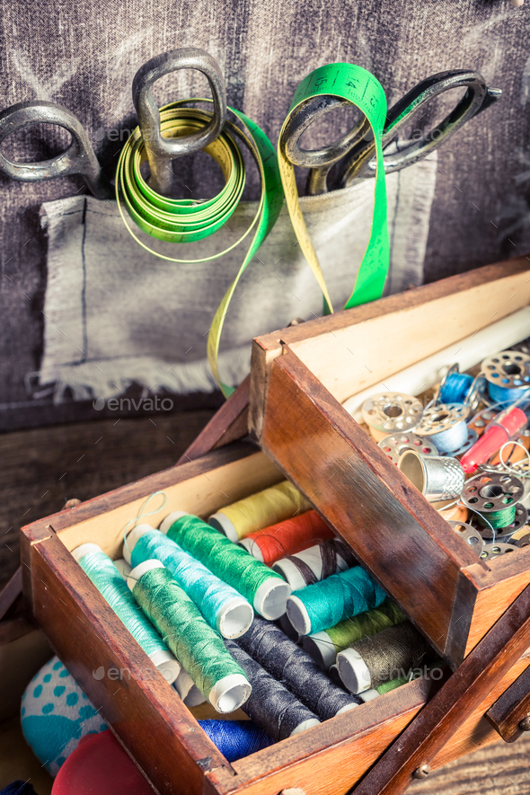 Vintage tailor's wooden box with needles, threads and buttons Stock