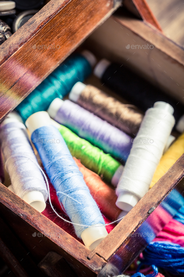 Old tailor's wooden box with buttons, needles and threads Stock Photo