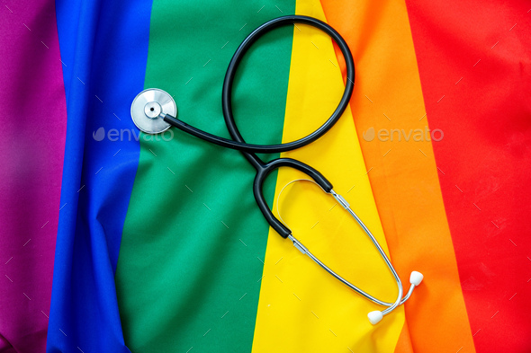 LGBT Health care. Medical Stethoscope on rainbow pride flag background, overhead view