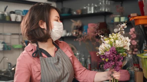 Woman Making Fresh Bouquet in Flower Shop. Female Florist Wears Mask Illness To Prevent
