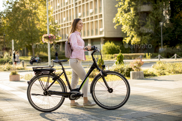 Young woman with modern city electric e-bike clean sustainable urban transportation