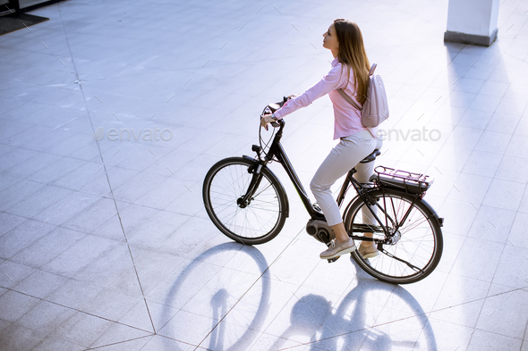 Young woman with modern city electric e-bike clean sustainable urban transportation