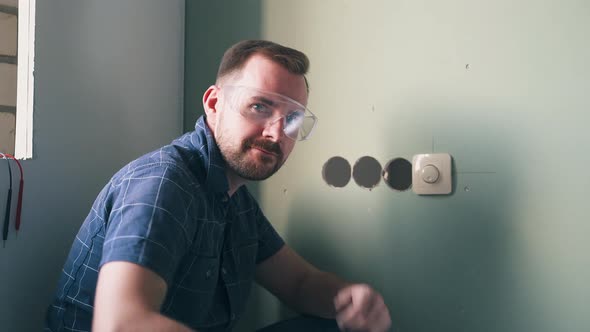 Builder Proud of Finished Work Shows Switch on Wall Closeup alt