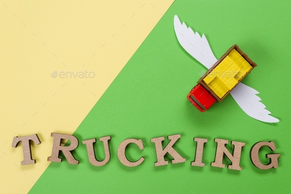 Abstract picture of a truck with wings and a word of trucking. Green background. Cargo