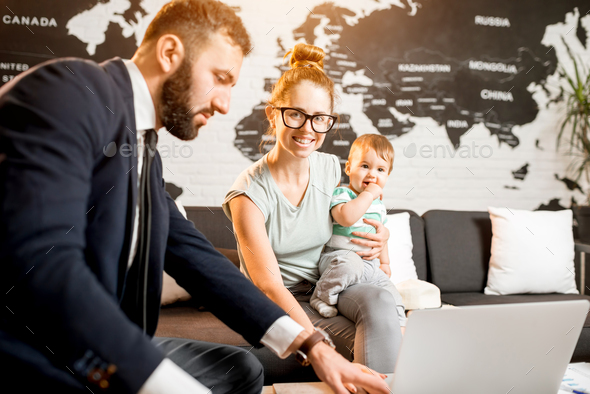 Woman and baby boy with travel agent at the office