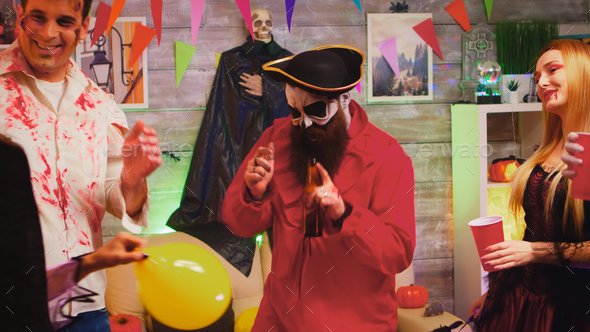 Crazy Halloween party with different funny and scary characters dancing in decorated room